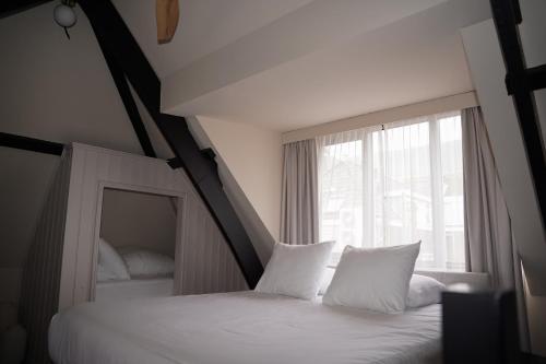 a bedroom with two beds and a large window at Boutique Hotel Johannes in Delft