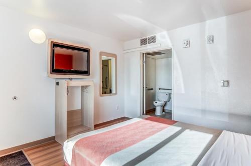a bedroom with a bed and a tv on the wall at Motel 6 Fort Collins, CO in Fort Collins