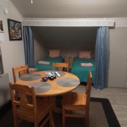 a room with a table and chairs and two beds at Perniön Majoitus 6 in Perniö