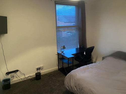 a bedroom with a desk and a bed and a window at Harcourt Road in Nottingham