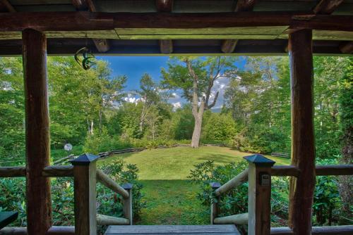 a view from the porch of a cabin with a view of a yard at Winds Aloft in Newland