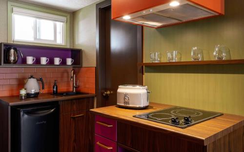 a kitchen with a stove and a counter top at Hotel Zed Victoria in Victoria
