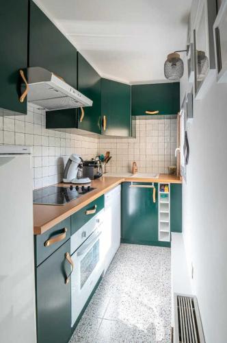 Il comprend une cuisine avec des placards verts et du carrelage blanc. dans l'établissement Elegant 2 bedroom triplex with parking Honfleur, à Honfleur