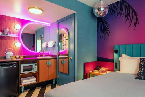 a bedroom with a bed and a sink and a mirror at Hotel Zed Victoria in Victoria