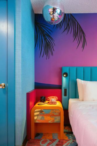 a colorful bedroom with a bed and a table at Hotel Zed Victoria in Victoria