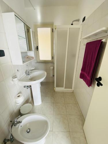a white bathroom with a sink and a toilet at Marasusa Apartments Maestrale 216C in Parghelia