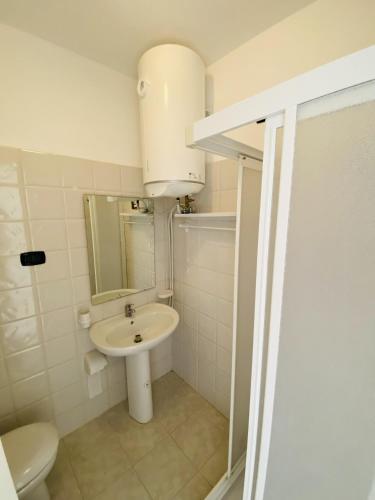 a white bathroom with a sink and a toilet at Marasusa Apartments Maestrale 216C in Parghelia