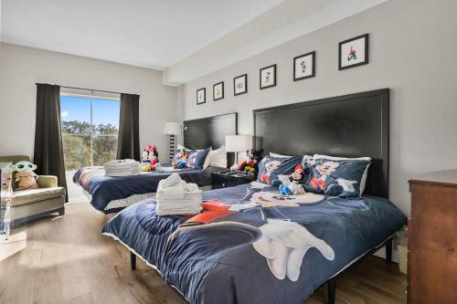 a bedroom with two beds and a large window at 5 Minutes to Disney Free Shuttle King & queen bed in Orlando