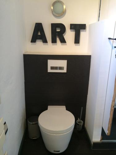 La salle de bains est pourvue de toilettes avec un panneau au-dessus. dans l'établissement Bed and breakfast Bergerie de Peymeyan, à Saint-Paul-en-Forêt