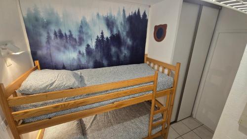 a bunk bed in a room with a painting on the wall at Cosy'PY in Bagnères-de-Bigorre