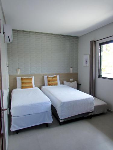 a bedroom with two beds and a window at Mar e Lar in Maragogi