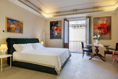 a bedroom with a bed and a table and chairs at B&B Cantiere dell'anima - Rooms of art in Trapani