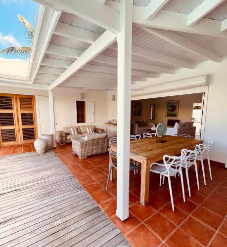 a living room with a wooden table and chairs at Villa Laucaly Orient Bay in Orient Bay