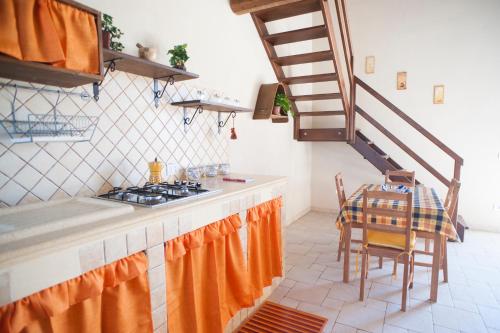 a kitchen with a stove and a table and a staircase at I 5 SENSI in Marina di Modica