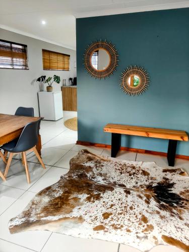 a dining room with a table and two mirrors at Harrismith Country Cottage in Harrismith