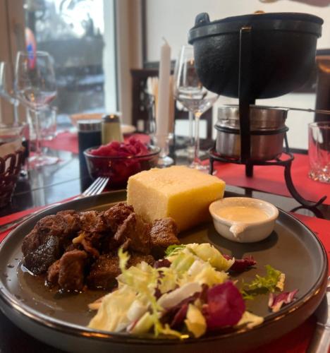 a plate of food with cheese and salad on a table at Pensiunea Alpin Predeal in Predeal