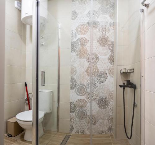 Un baño con ducha y WC. en Encanto room, en Niš