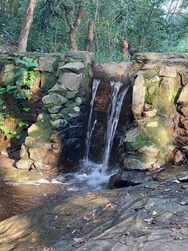 a waterfall on the side of a stone wall at Cabaña El Bosque in Independencia