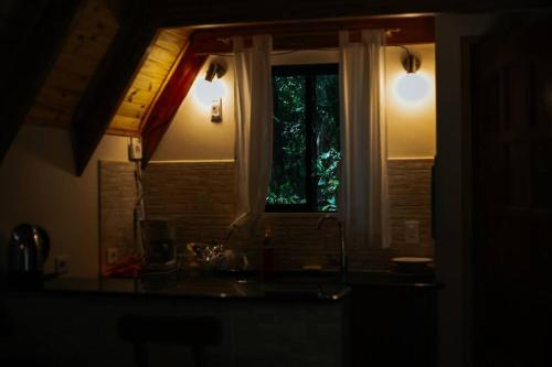 eine dunkle Küche mit einem Fenster und einem Waschbecken in der Unterkunft Cabaña El Bosque in Independencia