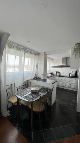 une cuisine avec une table et des chaises dans une cuisine dans l'établissement Apparemment spacieux et lumineux pour 6 voyageurs, à Strasbourg