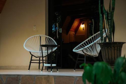 two white chairs sitting in front of a door at Cabaña El Bosque in Independencia