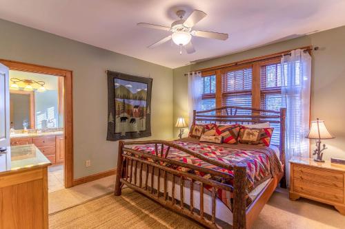 Un dormitorio con una cama y un ventilador de techo. en Bearfoot Lodge at Echota, en Boone