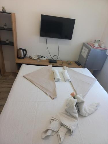 a bedroom with a bed with two towels on it at Hotel Duga in Novi Sad
