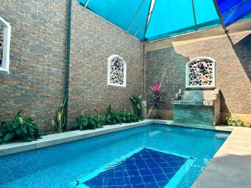 a swimming pool with a fountain in a building at Tropical Inn Hotel in Guayaquil