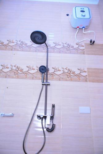 a shower in a bathroom with a hose on the floor at Villa Home Hotel & Apartment in Dodoma