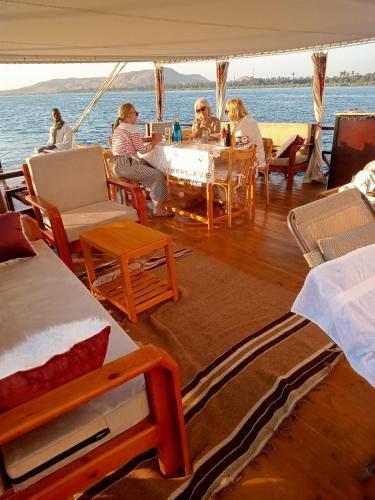 a group of people sitting at a table on a boat at Nubian Sandal in Aswan