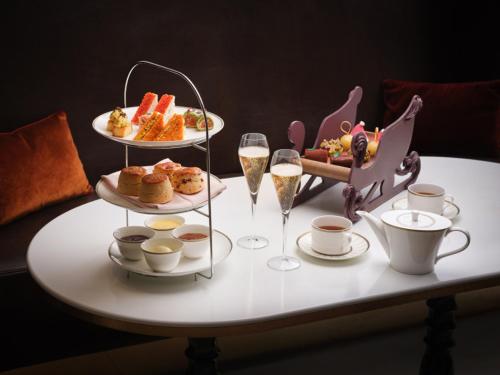 a table with a tray of food and glasses of champagne at Four Seasons Hotel London at Tower Bridge in London