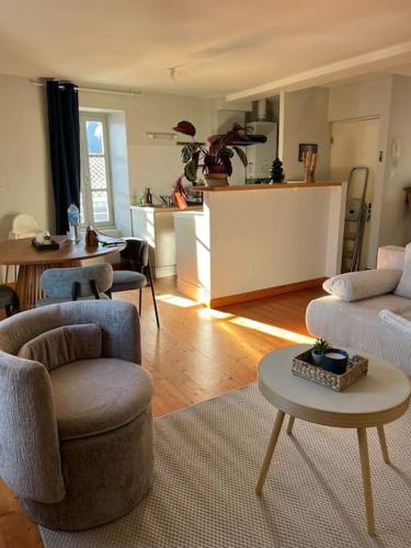 Il comprend un salon avec deux chaises et une table ainsi qu'une cuisine. dans l'établissement Appartement Charlie, Wifi, Charme, Centre Historique, à La Rochelle