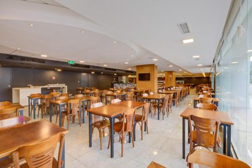 a dining room with wooden tables and chairs at ibis Rio de Janeiro Nova America in Rio de Janeiro