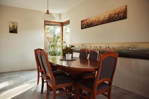 a dining room with a wooden table and chairs at Domki na Kaszubach - nad jeziorem z balią i sauną in Bytów