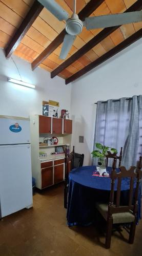 a dining room with a table and a refrigerator at Casa familiar estilo colonial a metros del lago in San Bernardino
