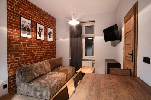 un soggiorno con un divano e un muro di mattoni di DREAM APARTMENTS - Wschodnia 34 a Łódź