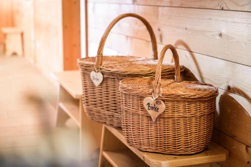 Dos cestas de mimbre colocadas en un estante en una pared en Froetscherhof, Urlaub auf dem Bio-Bauernhof in Brixen, Appartments, en Bresanona