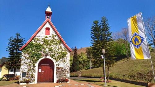 a small church with a flag in front of it at Casa - Centro Px Matriz c/ Churrasqueira, 2 Suítes in Poços de Caldas
