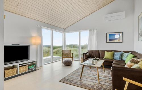 a living room with a couch and a tv at Awesome Home In Løkken With Kitchen in Løkken