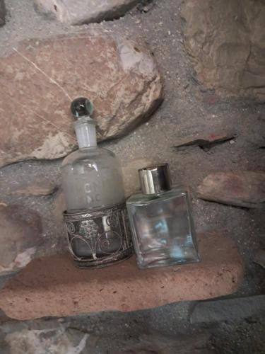 two glass bottles sitting on top of a rock at The Mandarine, Orangery Retreat in Tursi