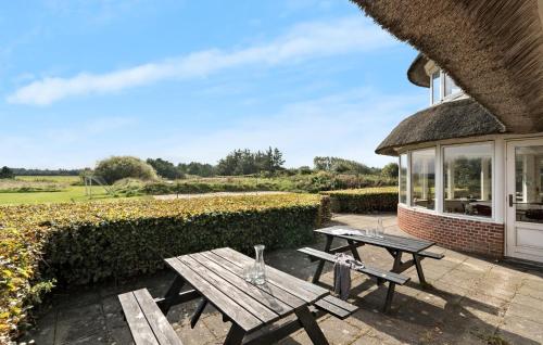 una mesa de picnic en un patio junto a un edificio en Twelve-Bedroom Accommodation In Ulfborg, en Fjand Gårde