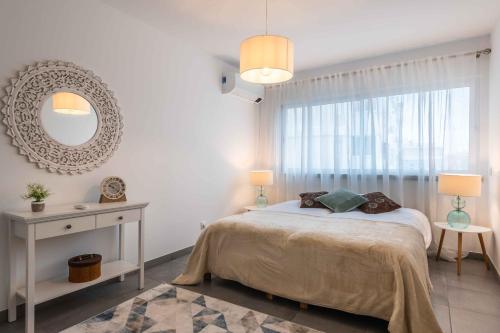 a bedroom with a bed and a large window at Caravelas 2-Bedroom Apartment with Pool - 50m from the Beach in Armação de Pêra