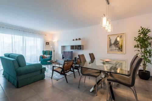 a living room with a dining table and chairs at Caravelas 2-Bedroom Apartment with Pool - 50m from the Beach in Armação de Pêra