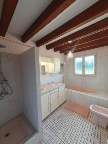 a bathroom with two sinks and a tub and a toilet at Maison 4 chambres pour 8 personnes in Ségos