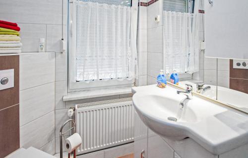 a white bathroom with a sink and a window at Doppelhaushälfte Blankensee in Wanzka
