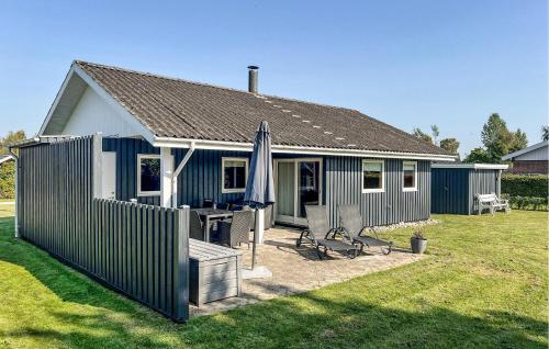 a blue and white house with a table and an umbrella at 3 Bedroom Lovely Home In Sydals in Neder Lysabild