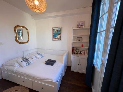 une petite chambre avec un lit blanc et une fenêtre dans l'établissement Appartement hyper centre, à Pornichet