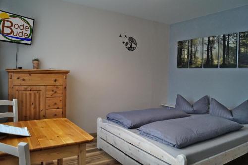 a bedroom with a bed and a wooden table at BodeBude in Thale