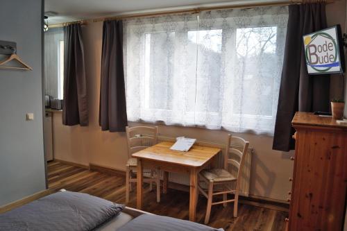 a room with a table and chairs and a window at BodeBude in Thale