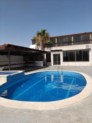 a large blue swimming pool in front of a building at Golden Horse Chalet And Club in Maḩaţţat al Jīzah